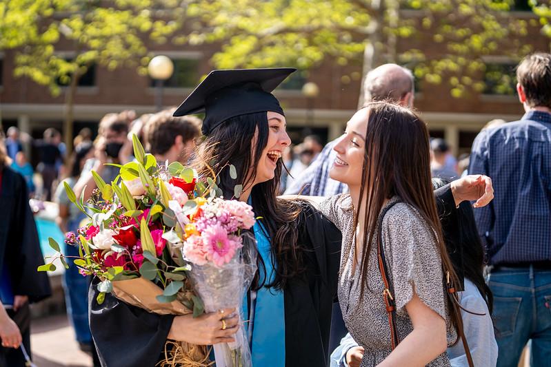 Graduating student greets a friend or family member.